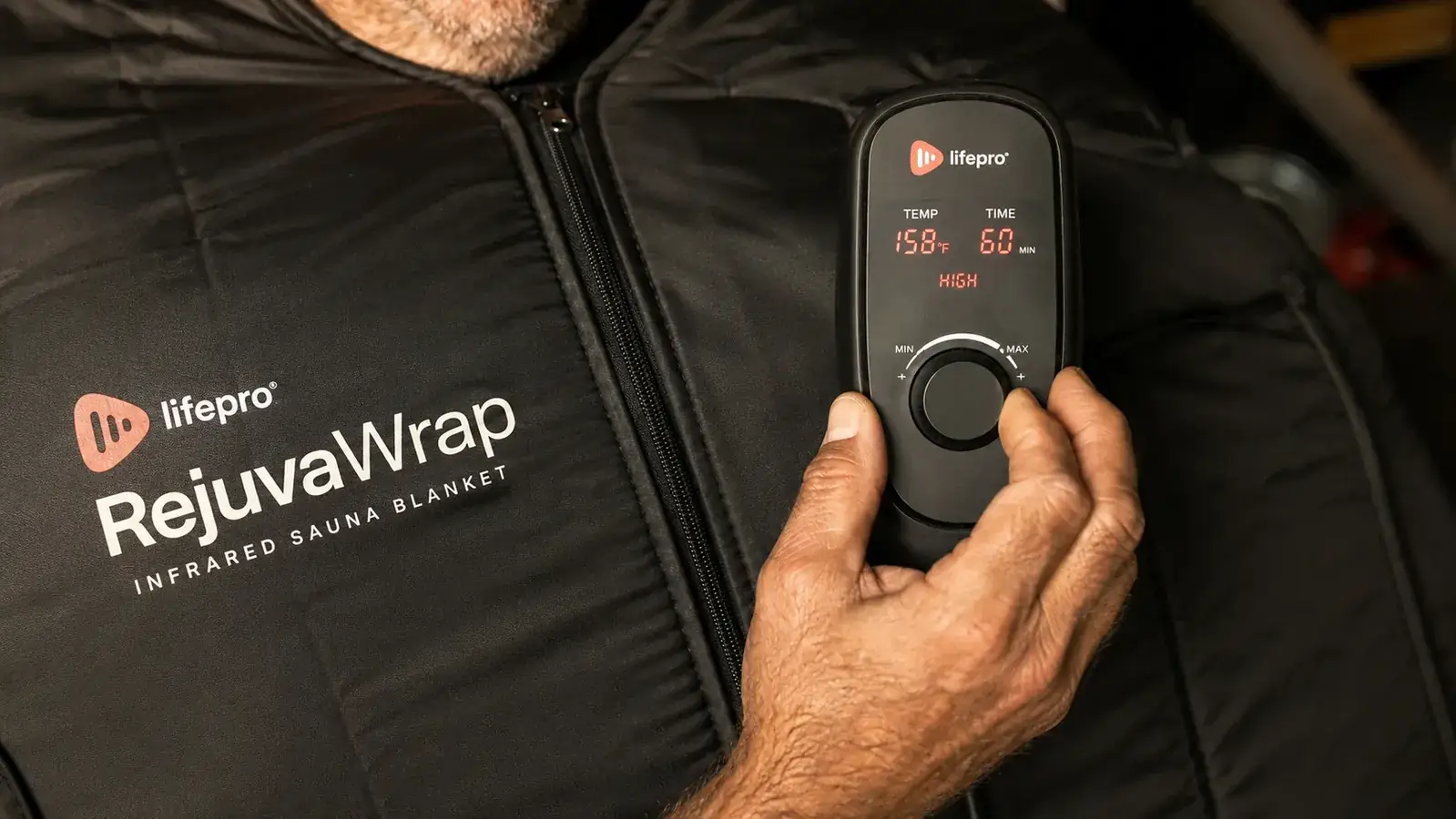 Close-up of a hand adjusting the temperature control zipper pouch on the Lifepro RejuvaWrap infrared sauna blanket